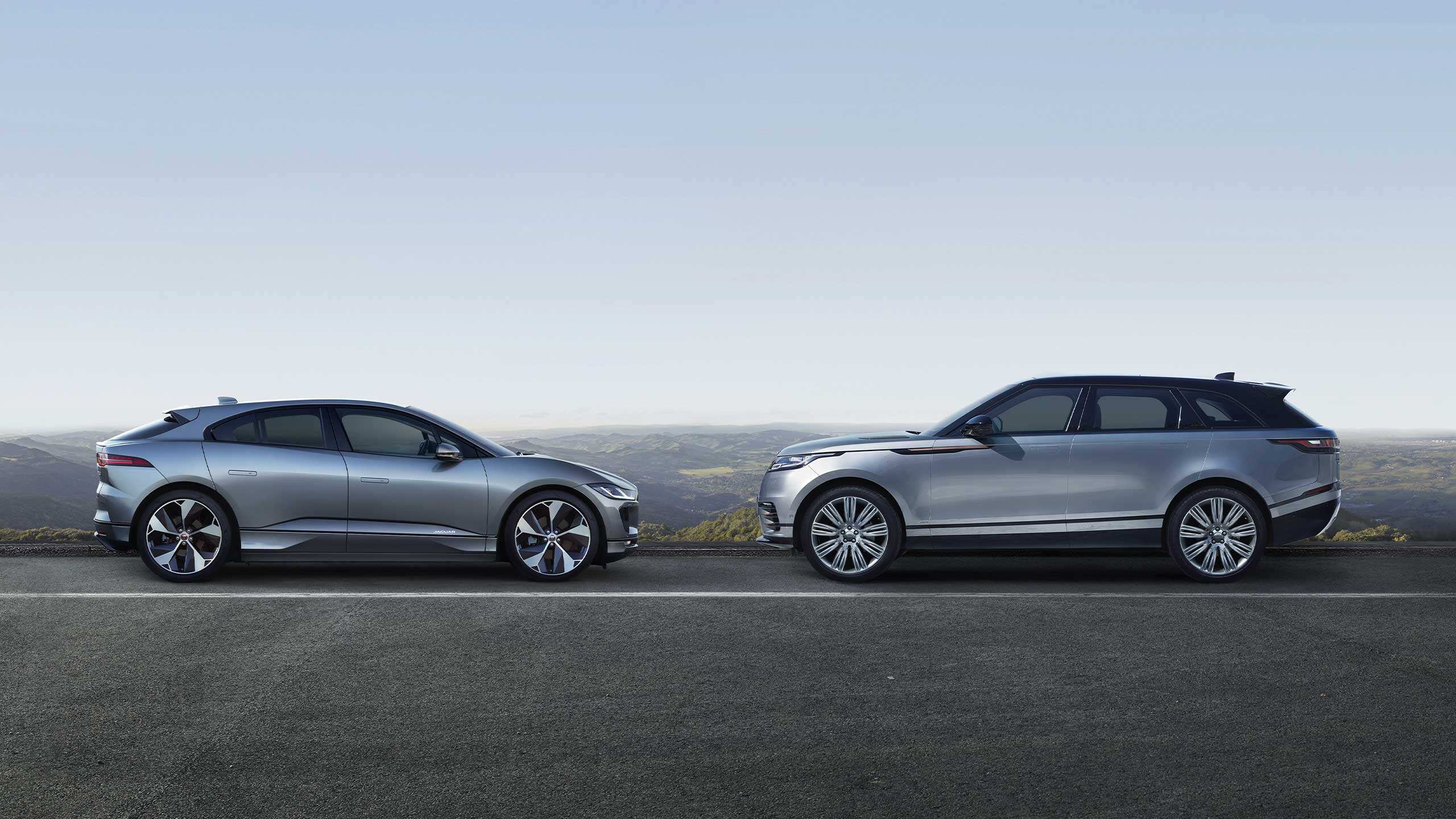 Parked Jaguar and Velar On Road side With A Mountain In Background